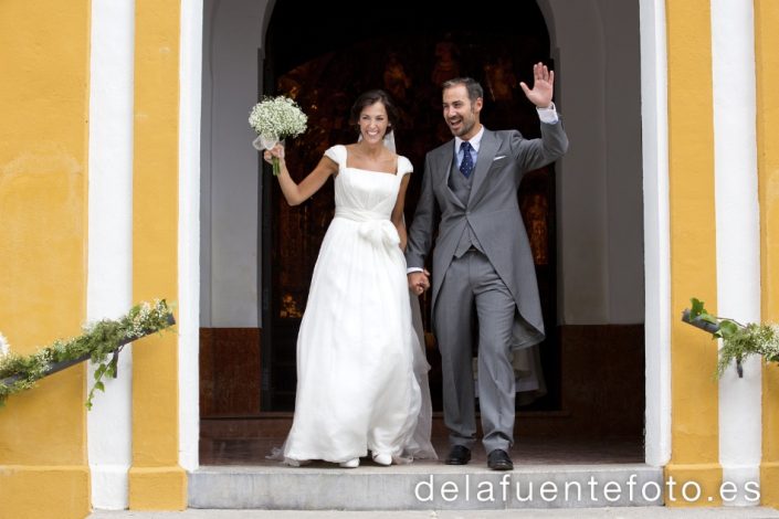 Reportaje de Bodas en Córdoba. Los novios saludan en la salida de la iglesia de Santo Domingo en Córdoba. Reportaje de boda en Córdoba hecho por De la Fuente Fotografía